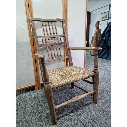 391 - Good quality antique Lancashire spindle back elm chair in good order with rush seat, showing good pa... 