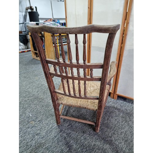 391 - Good quality antique Lancashire spindle back elm chair in good order with rush seat, showing good pa... 