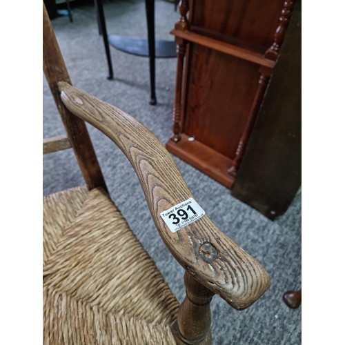 391 - Good quality antique Lancashire spindle back elm chair in good order with rush seat, showing good pa... 