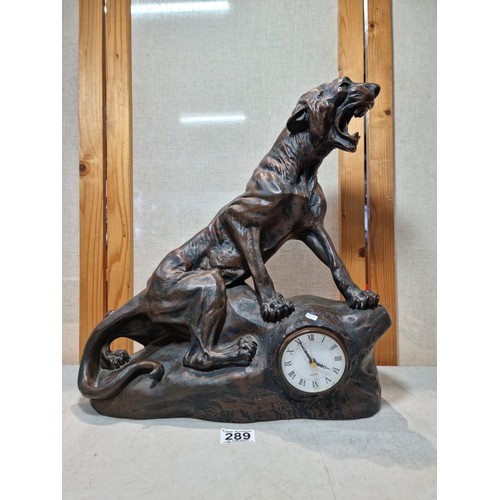 289 - A large and impressive figural mantel clock in the form of a big cat sitting on a rock, in cast resi... 