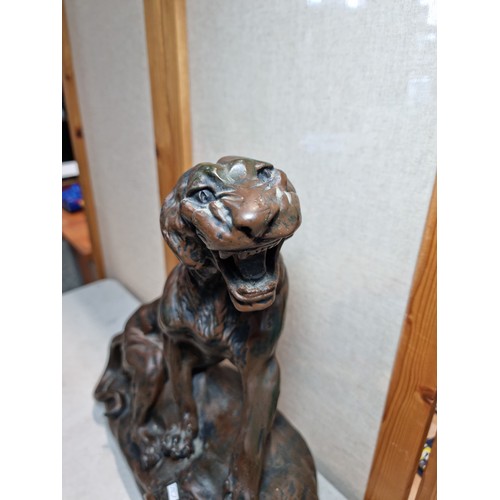 289 - A large and impressive figural mantel clock in the form of a big cat sitting on a rock, in cast resi... 