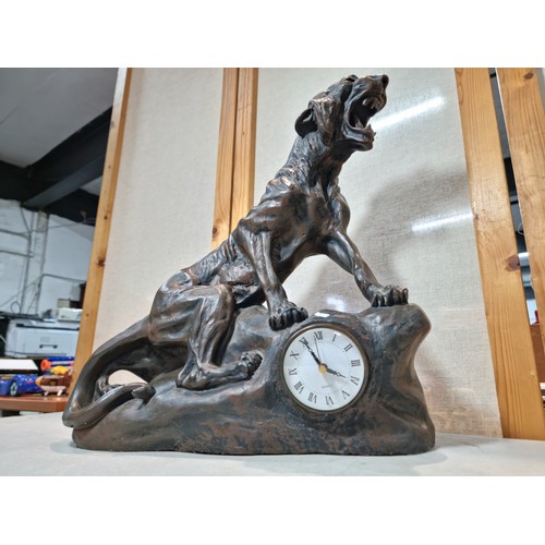 289 - A large and impressive figural mantel clock in the form of a big cat sitting on a rock, in cast resi... 