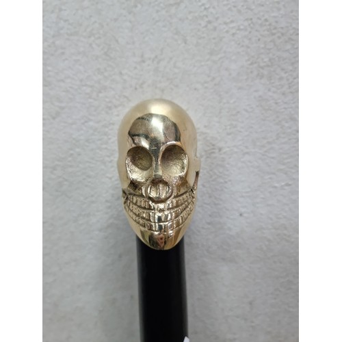 62 - Good quality brass skull formed topped walking stick in good order with metal tip to the end, has a ... 