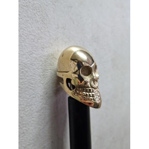 62 - Good quality brass skull formed topped walking stick in good order with metal tip to the end, has a ... 