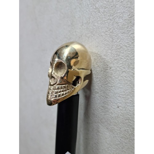 62 - Good quality brass skull formed topped walking stick in good order with metal tip to the end, has a ... 