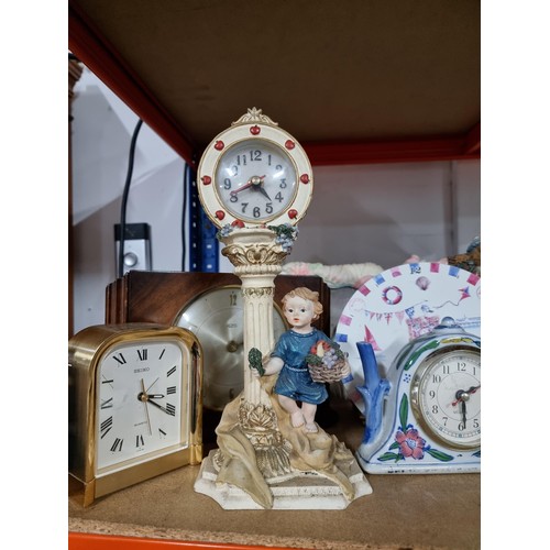 112 - Shelf containing a quantity of assorted clocks to include a framed and glazed quartz clock in the de... 