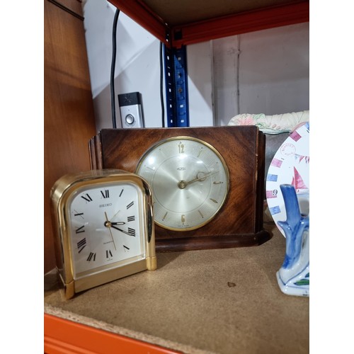 112 - Shelf containing a quantity of assorted clocks to include a framed and glazed quartz clock in the de... 