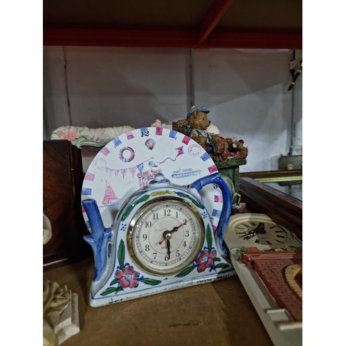 112 - Shelf containing a quantity of assorted clocks to include a framed and glazed quartz clock in the de... 