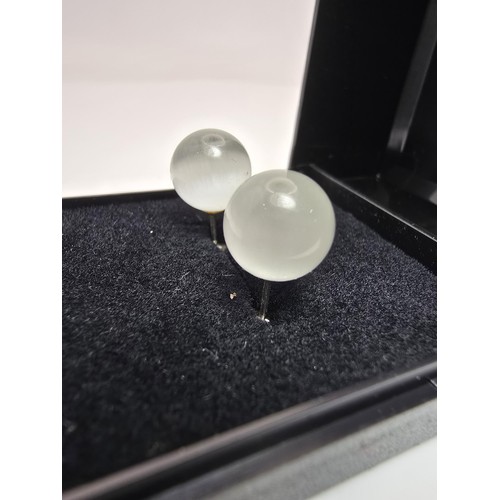 191A - A pair of unusual 925 silver stud earrings set with cats eye/moonstone type balls which have a  love... 