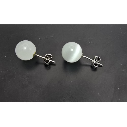 191A - A pair of unusual 925 silver stud earrings set with cats eye/moonstone type balls which have a  love... 