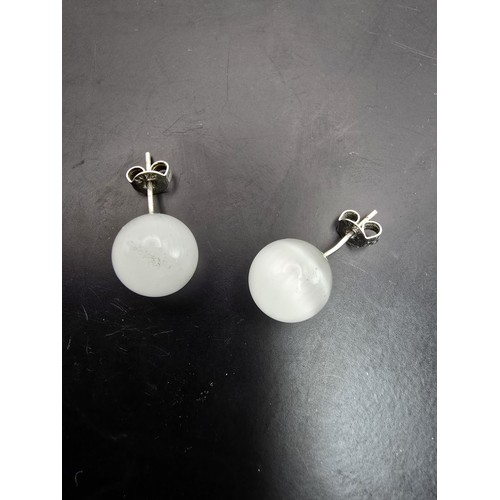 191A - A pair of unusual 925 silver stud earrings set with cats eye/moonstone type balls which have a  love... 
