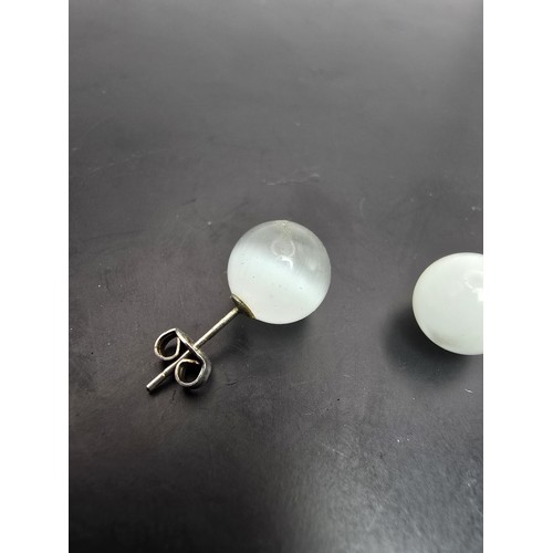 191A - A pair of unusual 925 silver stud earrings set with cats eye/moonstone type balls which have a  love... 
