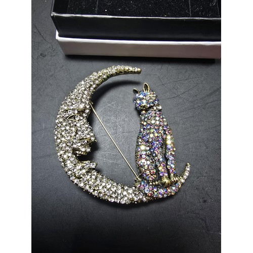 258 - An attractive large ornate costume brooch in the form of a cat and crescent moon which is heavily je... 