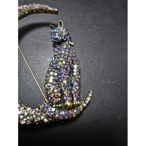 258 - An attractive large ornate costume brooch in the form of a cat and crescent moon which is heavily je... 
