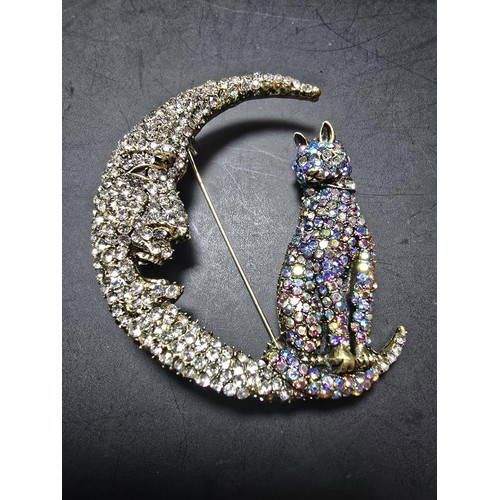 258 - An attractive large ornate costume brooch in the form of a cat and crescent moon which is heavily je... 