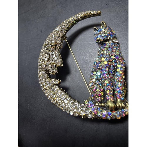 258 - An attractive large ornate costume brooch in the form of a cat and crescent moon which is heavily je... 