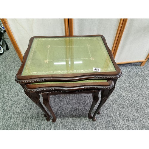 451 - A nest of 3 side tables, In mahogany with a green leather inlay and glass cover. One leg loose needs... 