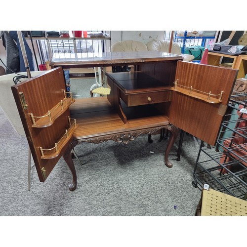 453 - A good quality reproduction drinks cabinate, featuring double flamed mahogany doors revealing a divi... 