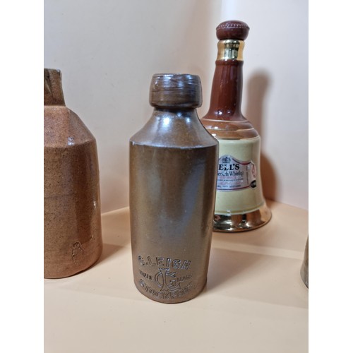 296 - A collection of 4x stone ware beer bottles all are named to include Slack & Cox of Manchester, G. Le... 