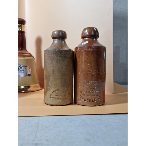 296 - A collection of 4x stone ware beer bottles all are named to include Slack & Cox of Manchester, G. Le... 