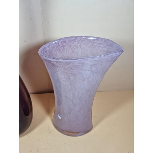 42 - 2x attractive coloured glass vases to include a purple long necked vase and a pink clouded glass vas... 