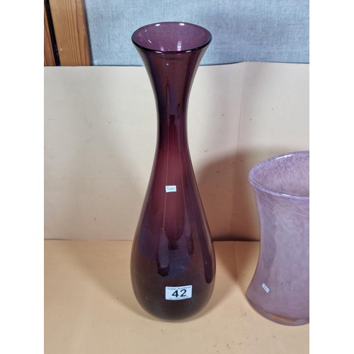 42 - 2x attractive coloured glass vases to include a purple long necked vase and a pink clouded glass vas... 