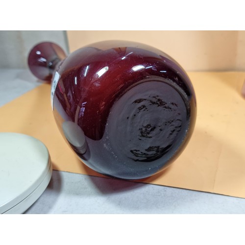 42 - 2x attractive coloured glass vases to include a purple long necked vase and a pink clouded glass vas... 