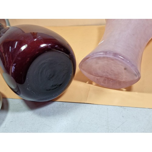 42 - 2x attractive coloured glass vases to include a purple long necked vase and a pink clouded glass vas... 