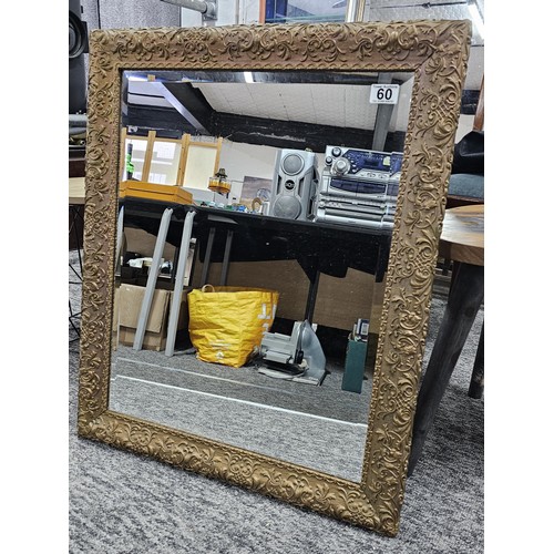 60 - A good quality ornate bevel edged mirror with an ornate frame depicting a floral design in good over... 