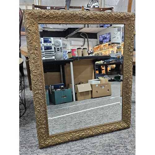 60 - A good quality ornate bevel edged mirror with an ornate frame depicting a floral design in good over... 
