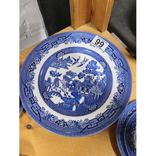 66 - A partial willow pattern dinner set to include 6x trios, 6x dinner plates and 6x bowls all in good o... 