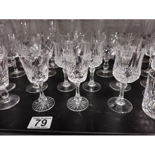 79 - A large collection of assorted cut glass crystal drinking glasses to include a total of 58 glasses t... 