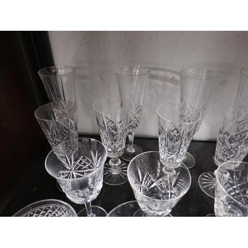 79 - A large collection of assorted cut glass crystal drinking glasses to include a total of 58 glasses t... 