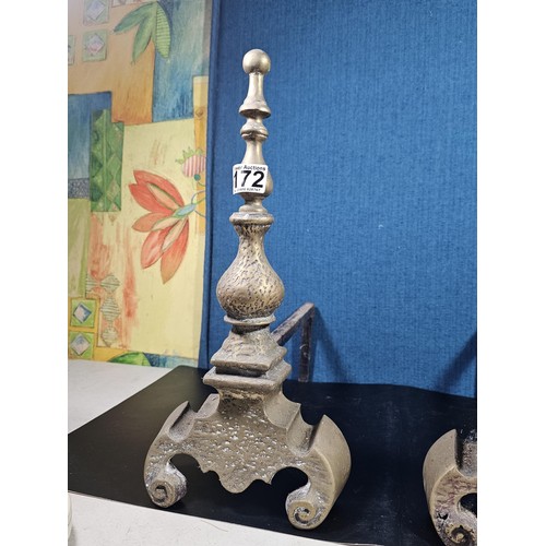 172 - A pair of good quality antique cast iron fire dogs standing on scrolled feet with finial top, both i... 