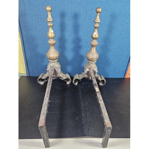 172 - A pair of good quality antique cast iron fire dogs standing on scrolled feet with finial top, both i... 