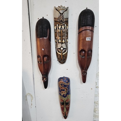 176 - A collection of 4 wall hanging original wooden ethnic face masks, 1 is in striking red, blue and yel... 