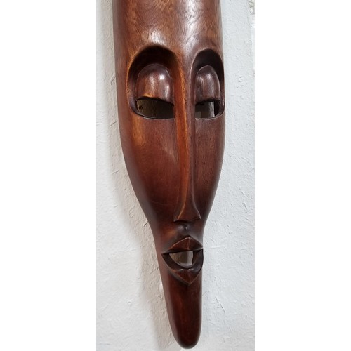 176 - A collection of 4 wall hanging original wooden ethnic face masks, 1 is in striking red, blue and yel... 