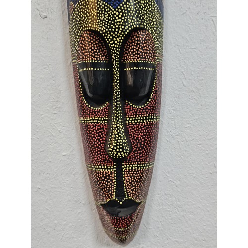 176 - A collection of 4 wall hanging original wooden ethnic face masks, 1 is in striking red, blue and yel... 