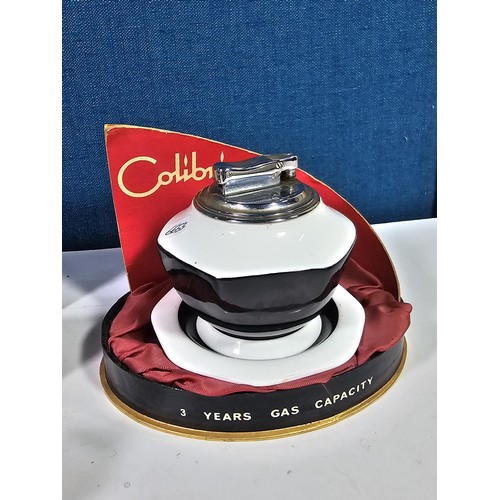 180 - A shelf containing a small quantity of collectables to include a Colibri ceramic tabletop lighter wi... 