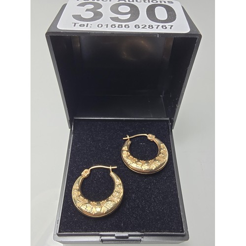 390 - A pair of pretty 9ct yellow gold half hoop earrings having an engraved design with maple leaves, the... 