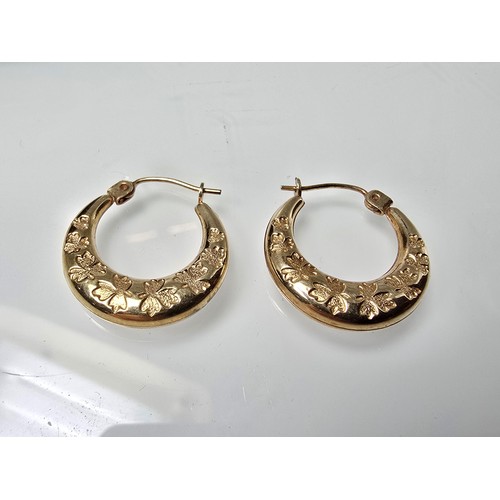 390 - A pair of pretty 9ct yellow gold half hoop earrings having an engraved design with maple leaves, the... 