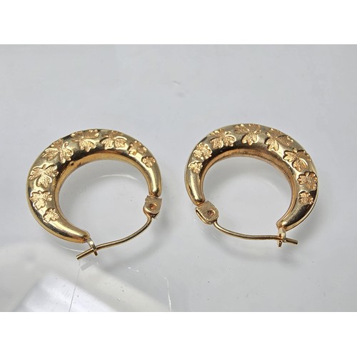 390 - A pair of pretty 9ct yellow gold half hoop earrings having an engraved design with maple leaves, the... 
