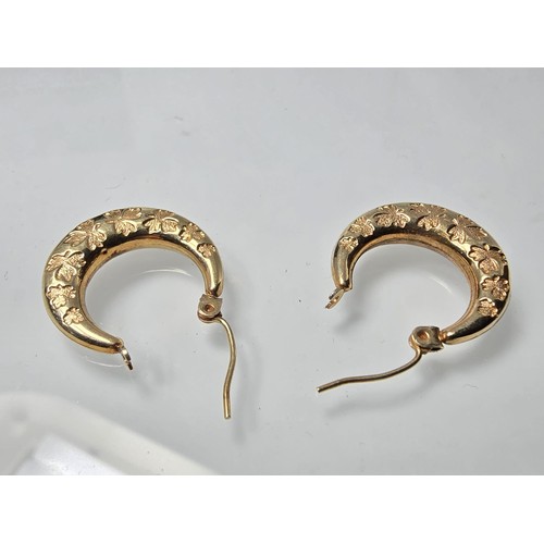 390 - A pair of pretty 9ct yellow gold half hoop earrings having an engraved design with maple leaves, the... 