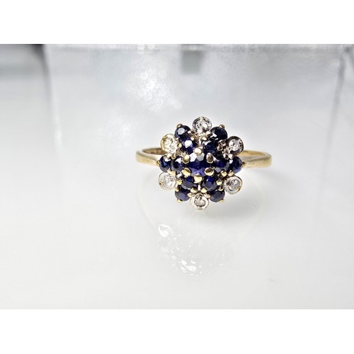 394 - A very pretty hallmarked 9ct yellow gold diamond and sapphire cluster ring set with 6 round cut diam... 