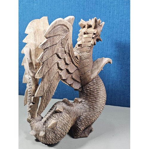 69 - A hand carved solid wood dragon figure, very well detailed. It has minor damage to 1 caw otherwise i... 