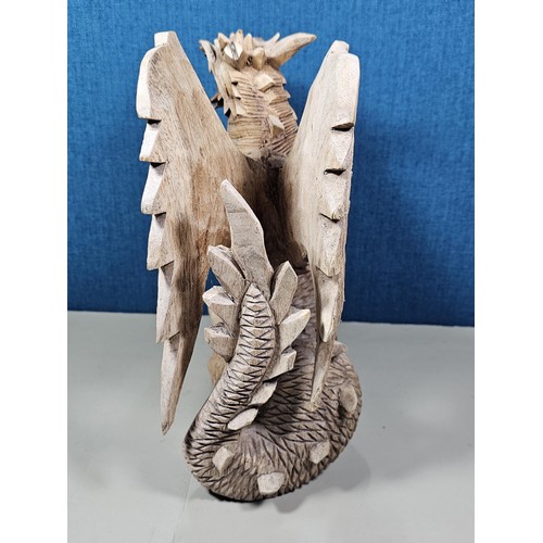 69 - A hand carved solid wood dragon figure, very well detailed. It has minor damage to 1 caw otherwise i... 