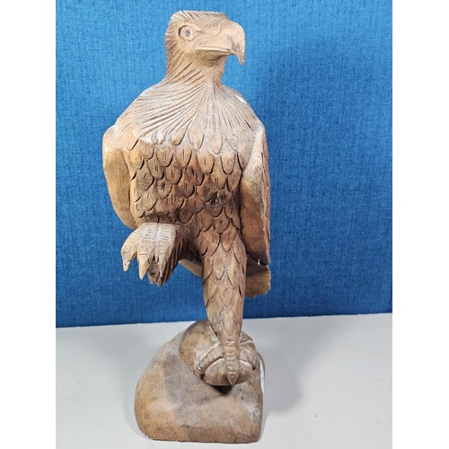 70 - A good quality hand carved solid wood eagle figure standing on a plinth, in very good detail. Has a ... 
