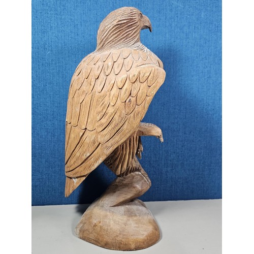 70 - A good quality hand carved solid wood eagle figure standing on a plinth, in very good detail. Has a ... 