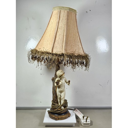 105 - A vintage resin figural lamp with a cherub to the base and an original vintage lampshade decorated w... 