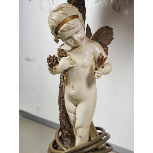 105 - A vintage resin figural lamp with a cherub to the base and an original vintage lampshade decorated w... 